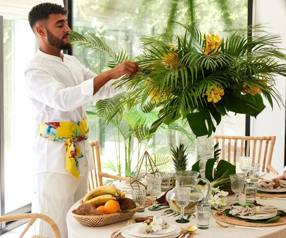 Arranging tropical flowers on a table set for a private lunch