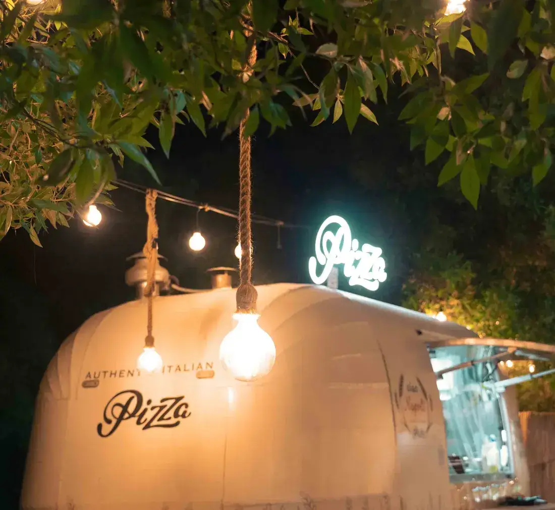 The truck and its Pizza sign at night